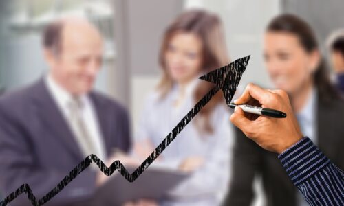 Gráfico ascendente sobre equipe Gráfico mostrando seta ascendente sobre um grupo de pessoas desfocado