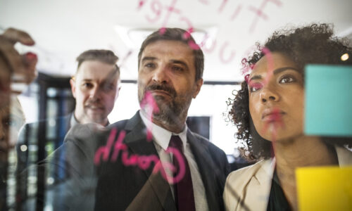 Equipe planejando Equipe de pessoas escrevendo em quadro transparente